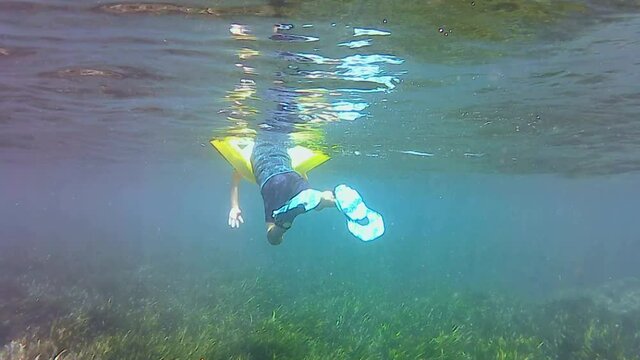 kid snorkeling and swimming over seagrass in Tabarca Islandin Alicante, Spain