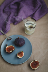 cozy still life with ripe fresh figs and purple napkin and candle on rustic background, flatlay, overhead view