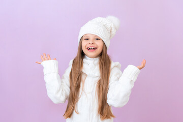 A girl in a white winter hat is waving her arms and rejoicing.