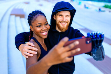 mixed race friends fitness training together outdoors taking selfie photo on smartphone camera