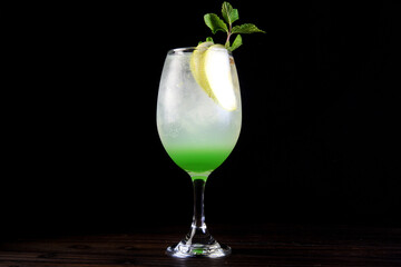 refreshing alcoholic drink, cozumel, mojito with tequila, gin, soda, lemon and mint isolated on black background