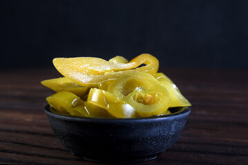 delicious mexican jalapeno peppers inside the canister isolated on black background.