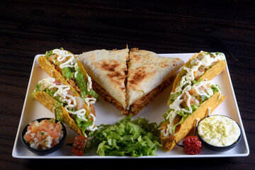 delicious mexican food tacos, guacamole, quesadillas, chilli, tortilla, burritos isolated on black background.