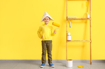Little painter with roller near color wall
