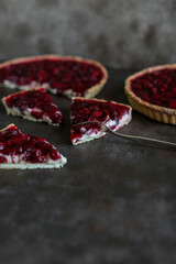 Shortcrust pastry tart with custard and cherry jelly. Pieces of delicious cherry tart on a dark table.