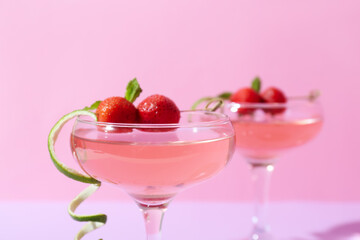 Glasses of tasty cosmopolitan cocktail on color background