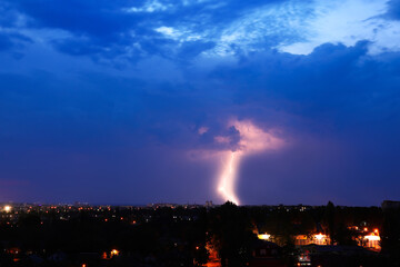 Dark sky with lightning over night city