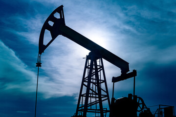 silhouette of a pumpjack on an oil well against the background of sky