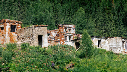 Fototapeta na wymiar ruins of an old brick industrial building among the forest in the mountains