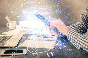 Double exposure of man's hand holding and using a digital device and data theme hologram drawing. Technology concept.