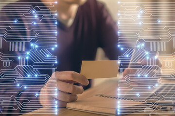 Double exposure of man's hands holding and using a digital device and tech theme hologram drawing....