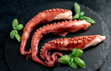 Boiled octopus tentacles on a stone background. Seafood.