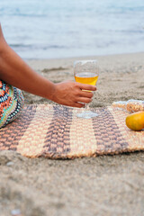 Unrecognizable woman with a glass of wine on the beach