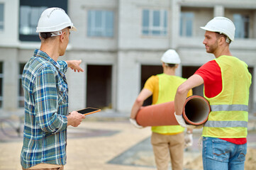 Experienced construction manager supervising young Caucasian male workers