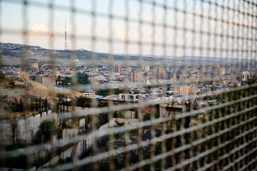 Beautiful view of the cityscape through the chainlink fence - Powered by Adobe