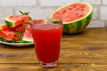 Glass of fresh watermelon juice on a wooden table