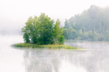 Foggy morning across the lake in the early summer morning
