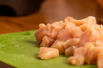 chicken pieces chopped up in a pile on a cuttingboard