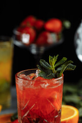 Colorful refreshing drinks for summer, cold strawberry lemonade juice with ice cubes in the glasses garnished with sliced fresh lemons