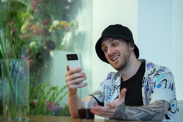 Happy Attractive Man Holding Mobile Phone, Smiling And Talking Via Video Call with Friends Remotely