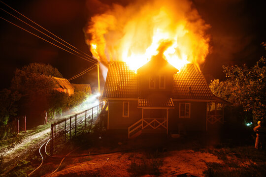 Wooden rural house is burning in fire at night