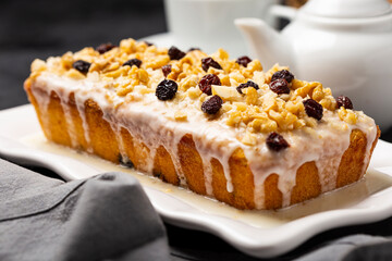 English cake topped with fondant, raisins and walnuts.