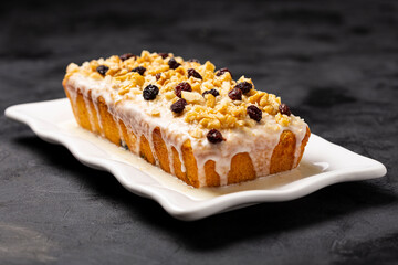 English cake topped with fondant, raisins and walnuts.