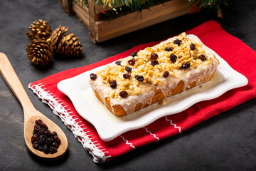 English cake topped with fondant, raisins and walnuts.
