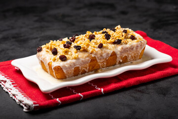 English cake topped with fondant, raisins and walnuts.