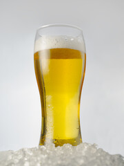 Glass goblet of light beer on a light background. One object. Minimalism. Refreshing drink....