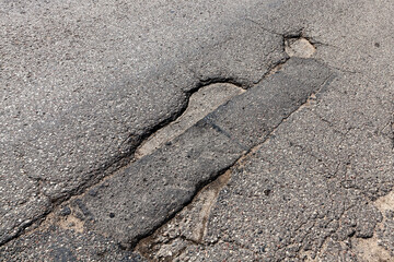 an asphalt road with a lot of holes and potholes