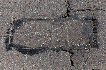 an asphalt road with a lot of holes and damage