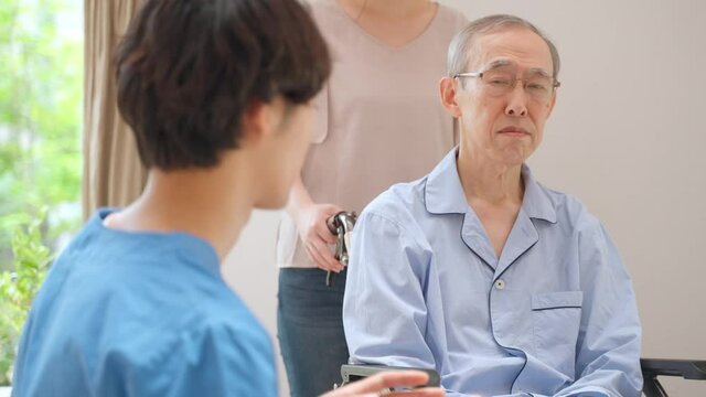 医師の話を聞く高齢の男性