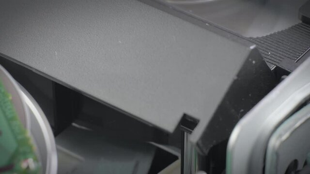 Closeup shot showing inside a vcr player. Vhs cassette being inserted into a vcr. Camera slowly rotating.