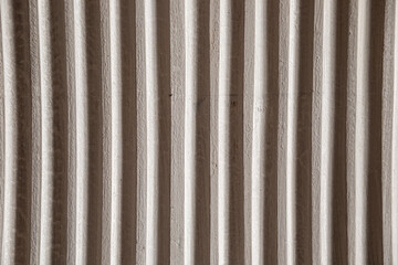 Gray wall. White ribs. Old white ribbed concrete background.