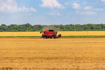 Fototapeta na wymiar Combine harvester working on a wheat field. Harvesting the wheat. Agriculture concept