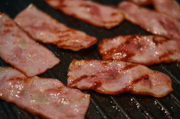 Close up of grilled bacon on the frying pan