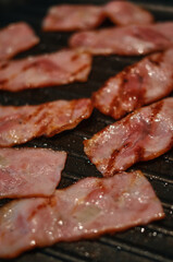 Close up of grilled bacon on the frying pan