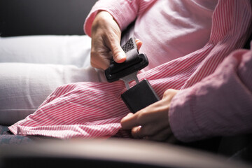Close-up shot of a woman fastening her seat belt in public bus..