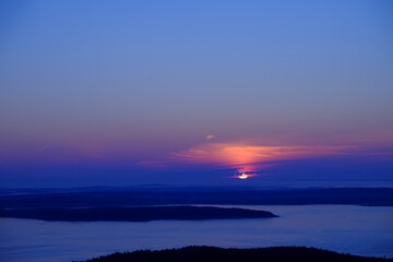 Fototapeta na wymiar Blue Sunrise coming up over Bar Harbor in Maine as seen from atop Cadillac Mountain