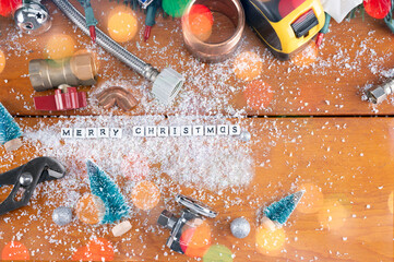 Holiday banner Merry Christmas and Happy New Year and white cubes with ​message MERRY CHRISTMAS 
on Construction and plumber tools composition