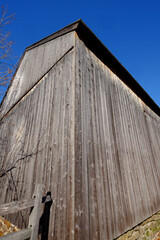 An abandoned old barn with weathered wood planks set off against a deep blue sky
