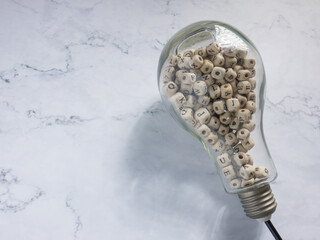 light bulb and alphabet wood cube on white marble for idea or think concept