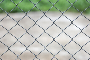 grate metal fence with blurred wire background.