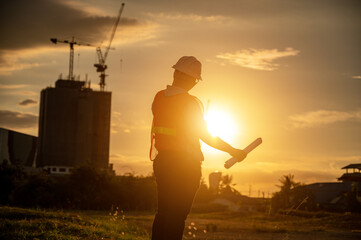 male engineer working construction site at Silhouette Sunset time