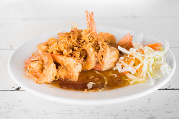 Fried shrimp with tamarind sauce on wooden table.