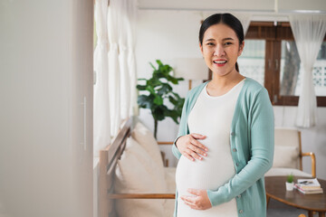 Asian young pregnant woman smile with big belly at home