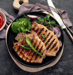 Sliced roasted pork meat on dark gray background. Organic gourmet food concept.