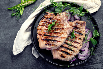 Sliced roasted pork meat on dark gray background. Organic gourmet food concept.
