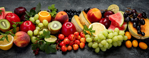 Assorted fresh fruits on dark background.